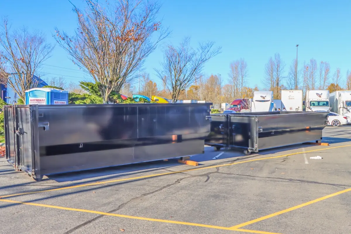 Professional dumpster rental service with roll-off container on residential driveway in Butler